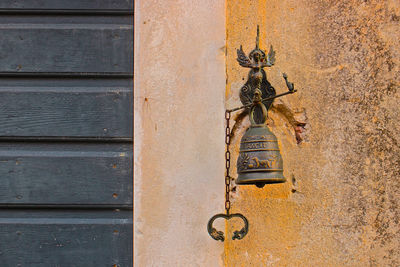 Close-up of cross on wall against building