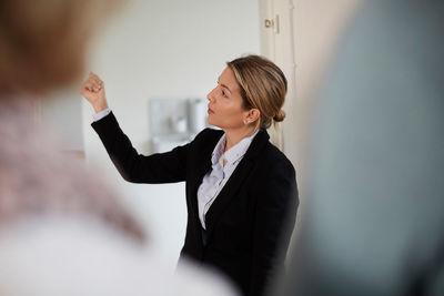 Confident female real estate agent showing new house