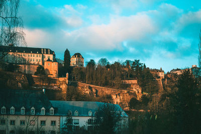 Buildings in city against cloudy sky