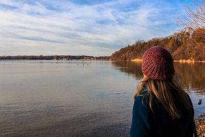 Rear view of woman standing in water against sky