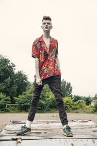 Full length portrait of young man standing against clear sky