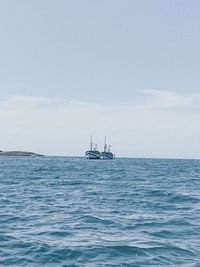 Sailboat sailing on sea against sky