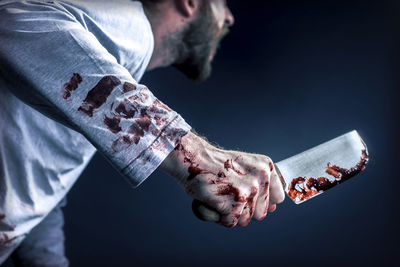 Close-up of hand holding paper over black background