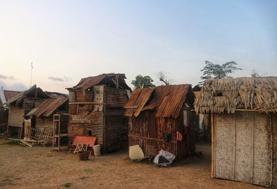 Houses by buildings against clear sky