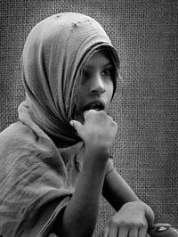 Girl wearing headscarf while looking away by burlap