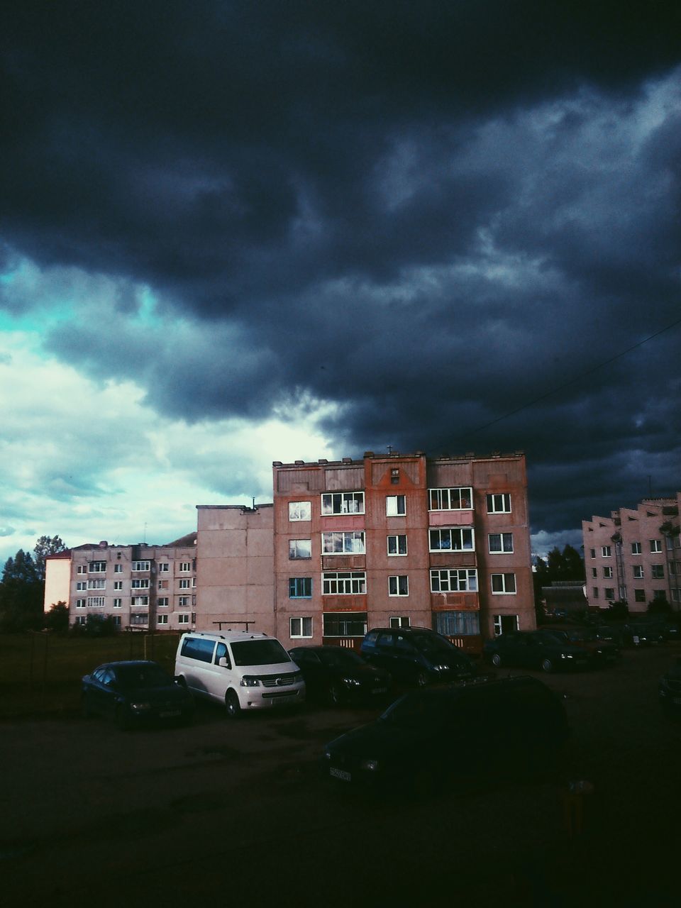 building exterior, architecture, built structure, sky, car, transportation, cloud - sky, cloudy, land vehicle, city, street, mode of transport, road, overcast, weather, residential building, storm cloud, residential structure, building, outdoors