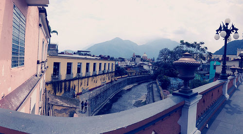 Bridge over buildings in city against sky