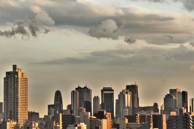 View of cityscape against cloudy sky