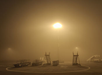 Illuminated street lights against sky in city