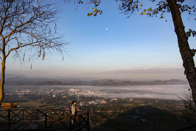 Aerial view of city by mountains against clear sky