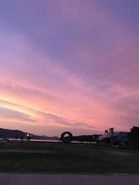 Scenic view of silhouette field against sky at sunset