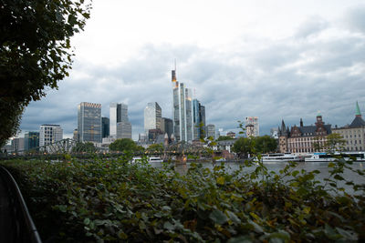 Buildings in city against cloudy sky