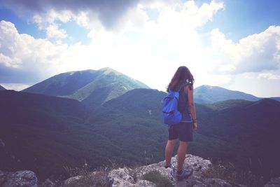 Woman standing on mountain against sky