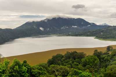 Scenic view of sea and mountains against sky