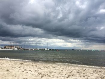 Scenic view of beach against cloudy sky