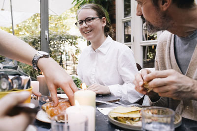 Happy woman enjoying food with family at restaurant