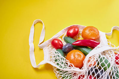 Close-up of fruits on table against yellow background