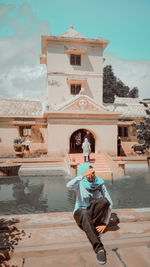 Man photographing with umbrella against sky