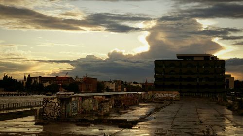 River with cityscape against cloudy sky