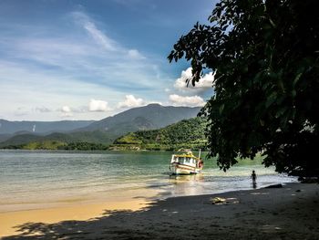 Boats in sea with mountain in background