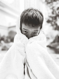 Close-up portrait of boy covering face with towel