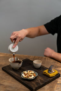 Cropped hand of person preparing food on table