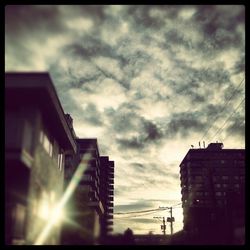 Low angle view of buildings against cloudy sky