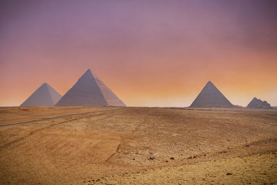 View the giza pyramids against beautiful purple sunset sky