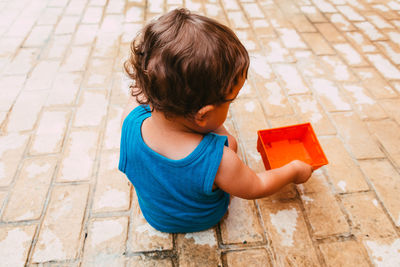 High angle view of boy playing on footpath