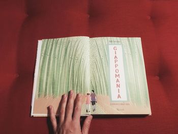 Midsection of woman reading book on table