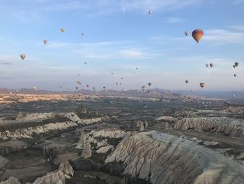 Hot air balloons flying over landscape