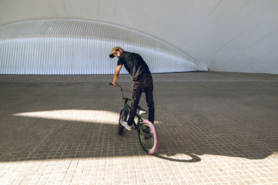 Man performing stunt on bicycle in city 