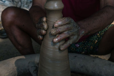 Midsection of man working on pottery wheel