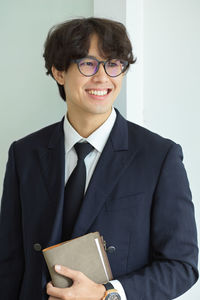 Portrait of businessman standing against white background