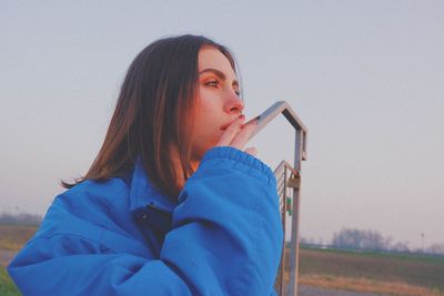 Portrait of woman looking away against sky