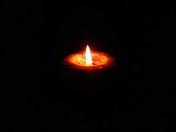 Close-up of lit candle against black background