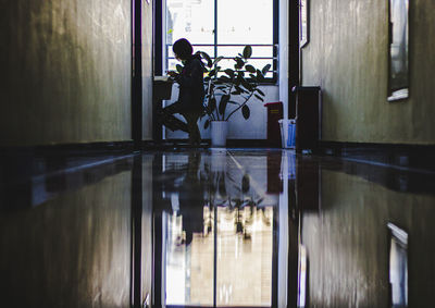 Reflection of man on window at home building