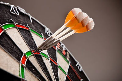 Close-up of darts on board against gray background