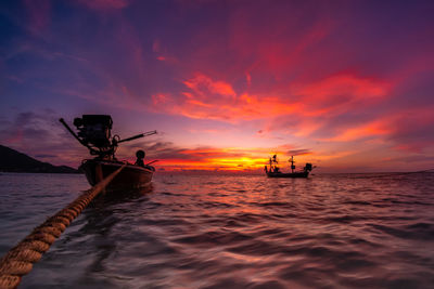 Boats on sea against sky during sunset