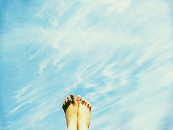 Low section of woman on beach against sky