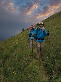 Man with umbrella standing on land against sky