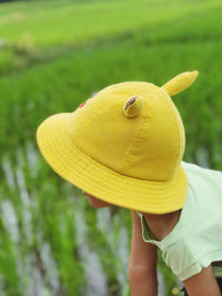 Midsection of woman holding yellow hat