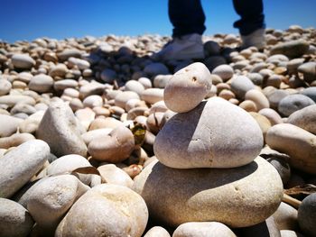 Stack of pebbles with man in background at beach