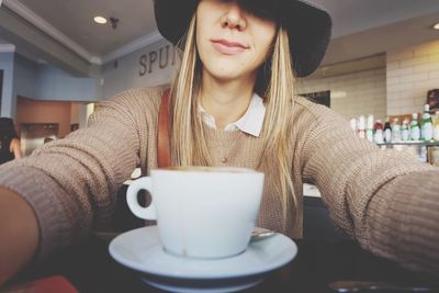 Woman holding coffee cup on table