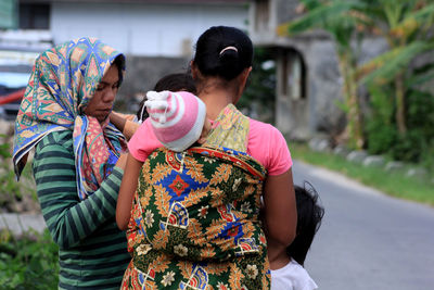 Rear view of mother and daughter outdoors