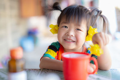 Portrait of cute girl drinking glasses on table