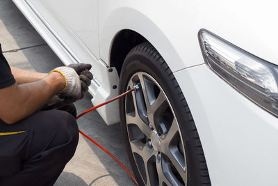 Midsection of mechanic repairing car