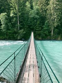 Footbridge over river in forest