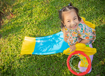 High angle view of cute girl lying on field