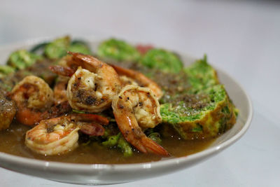 Close-up of seafood in plate against white background